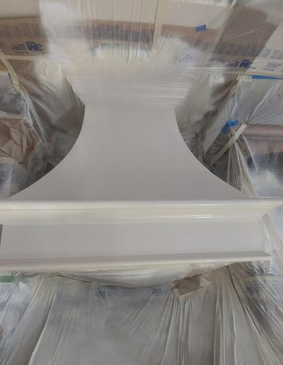 White kitchen stove vent hood being prepared and painted.